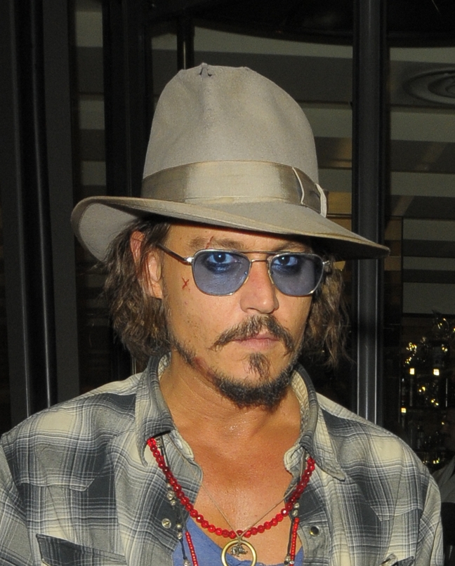 Johnny Depp, tan hat, blue tinted sunglasses, plaid shirt, blue tshirt, necklaces